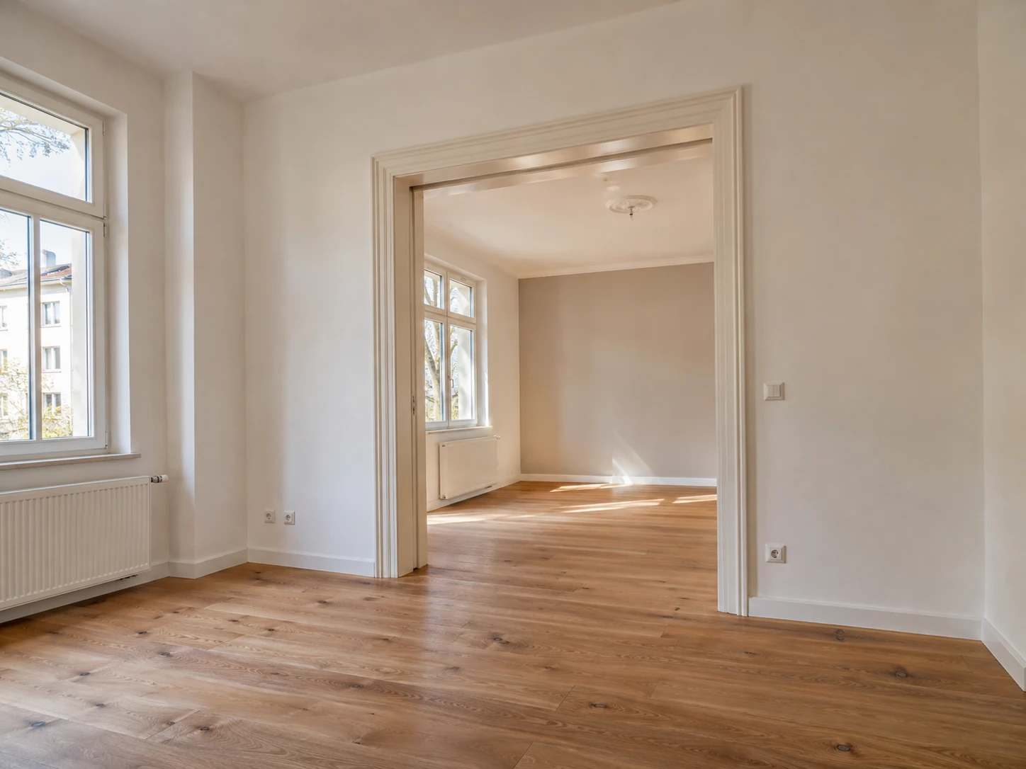 Helle sanierte Wohnräume mit Holzboden und erhaltenen Türrahmen